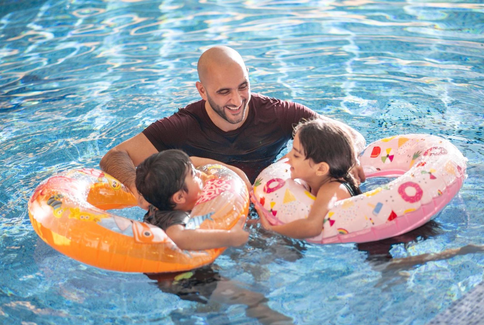 Delta Hotels By Marriott City Center Ad-Dauha Zewnętrze zdjęcie A father and two children in a swimming pool